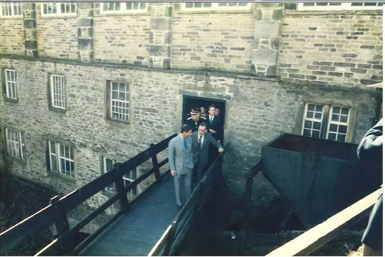 The party on the footbridge beside the mill’s stone wall and doorway