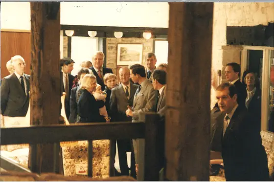 A crowd gathered inside the mill among heavy timber posts