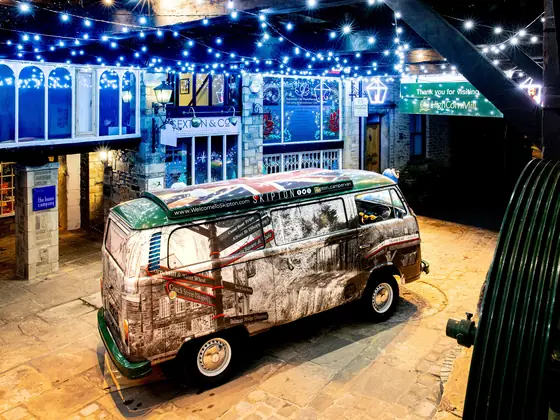 The George Leatt camper van parked in the courtyard under strings of lights