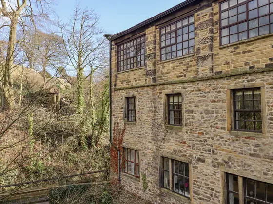 The mill building from the beck side, with bare winter trees in front