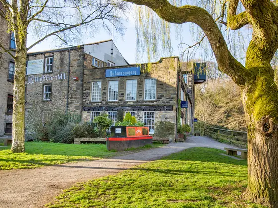 The mill lawn with a narrowboat planter named Emily and the home company&rsquo;s signs